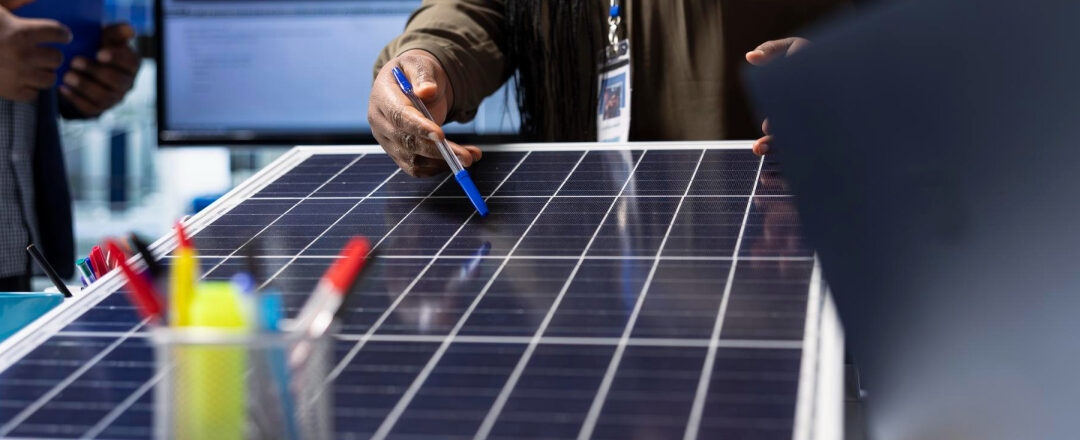 Personas revisando una placa solar en una instalación fotovoltaica en España, explicando los impuestos y beneficios fiscales en 2025.